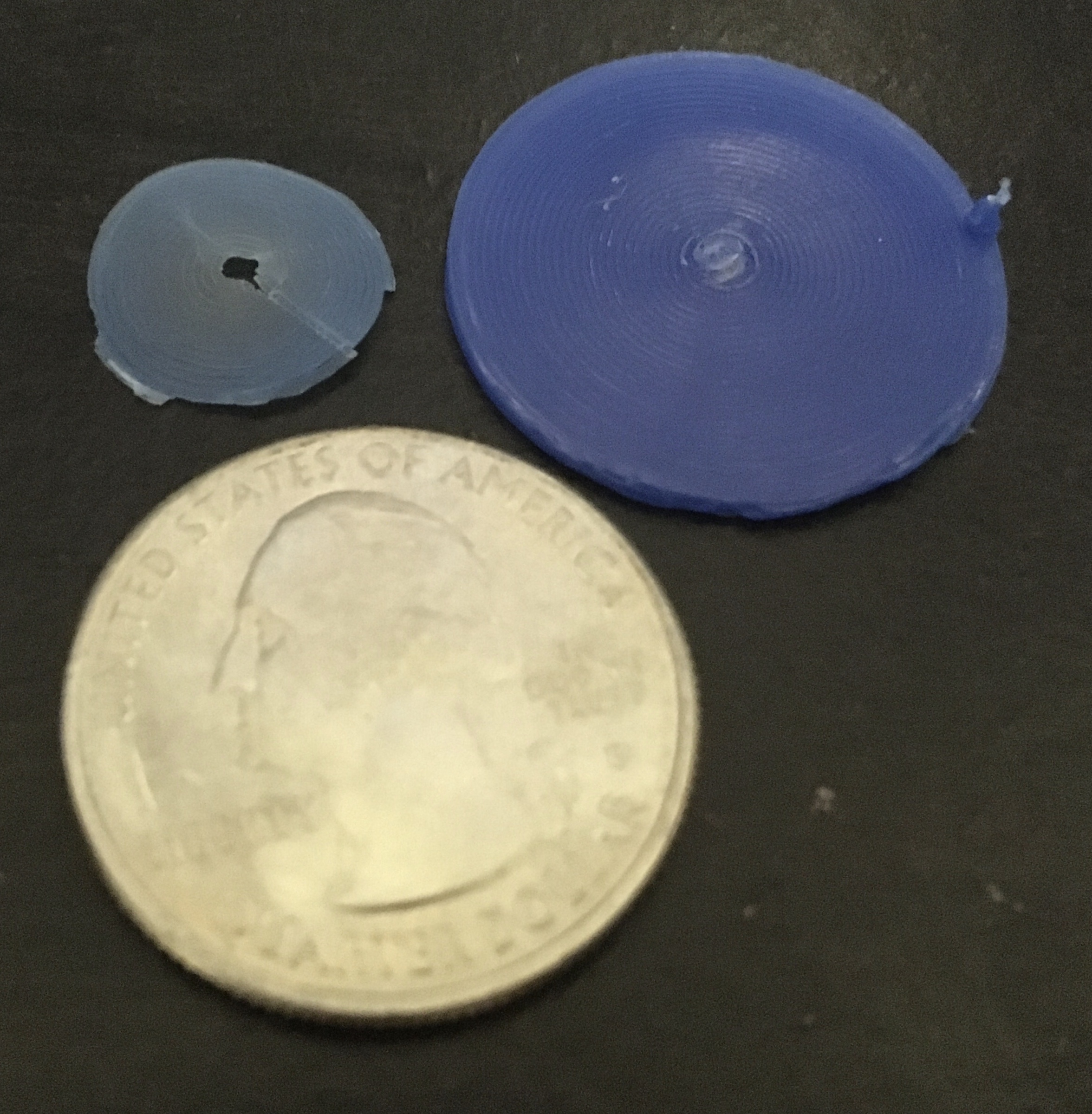 A small blue circle of plastic and a larger cylinder